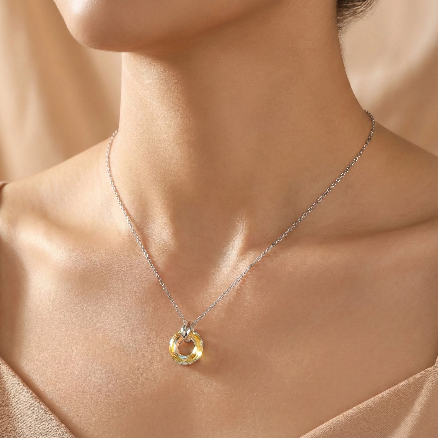 Necklace with a circular pendant on a model against a neutral background