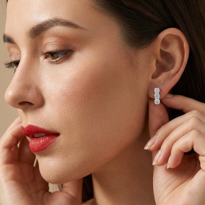 Close-up of a woman wearing a silver earring with a beige background