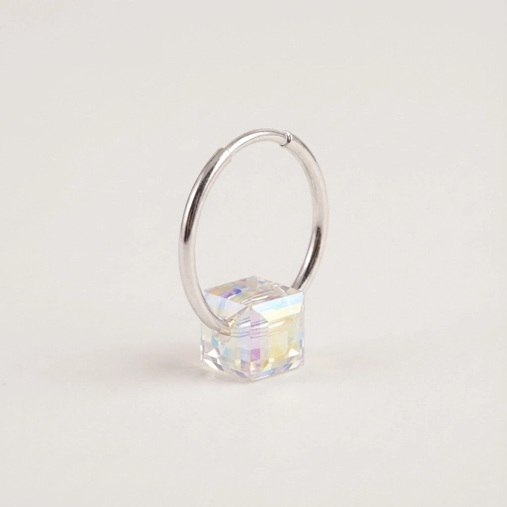 Silver hoop earring with a clear gemstone on a light gray background