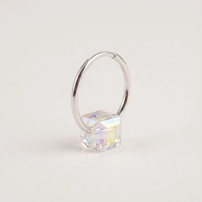 Silver hoop earring with a clear gemstone on a light gray background