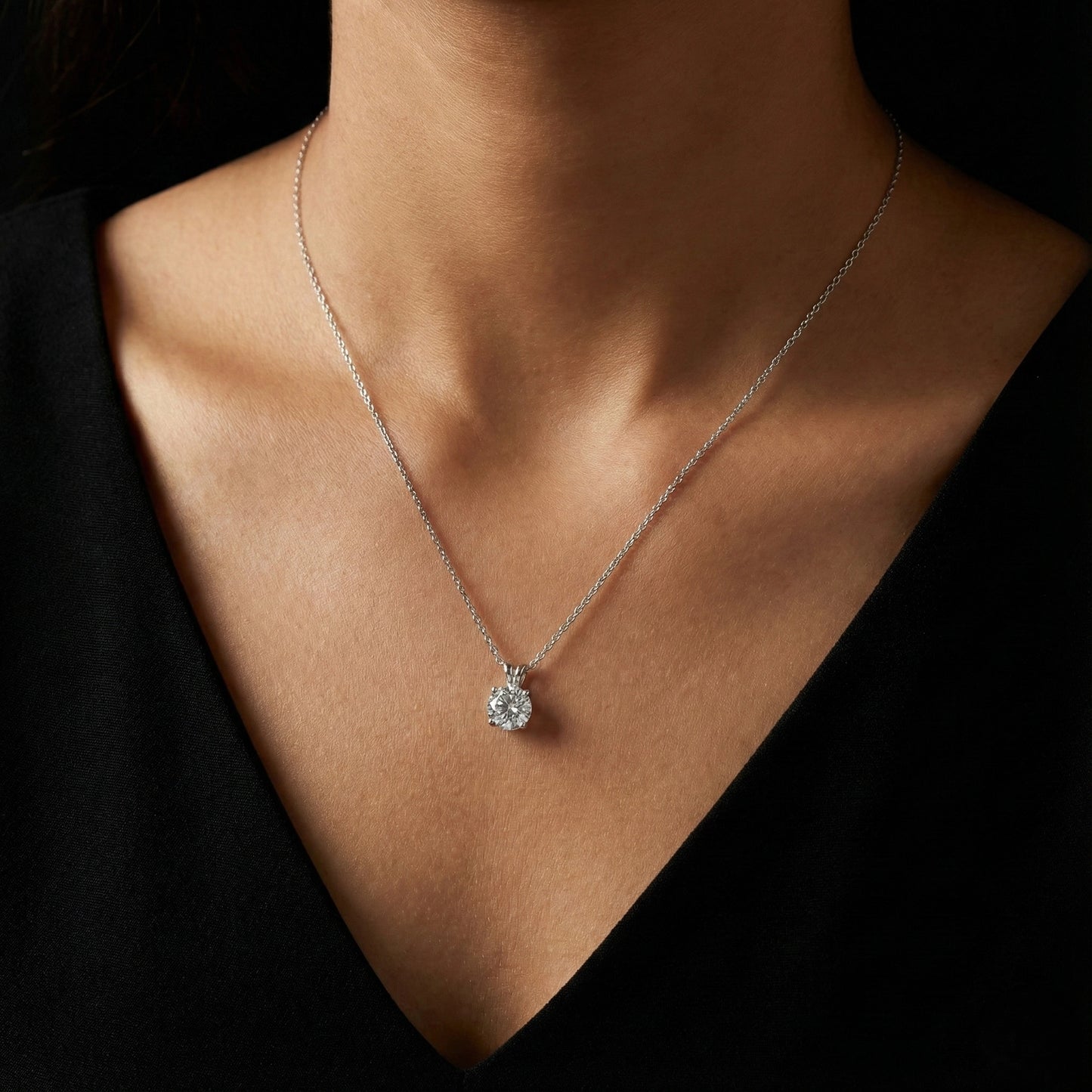 Necklace with a pendant worn by a person against a dark background