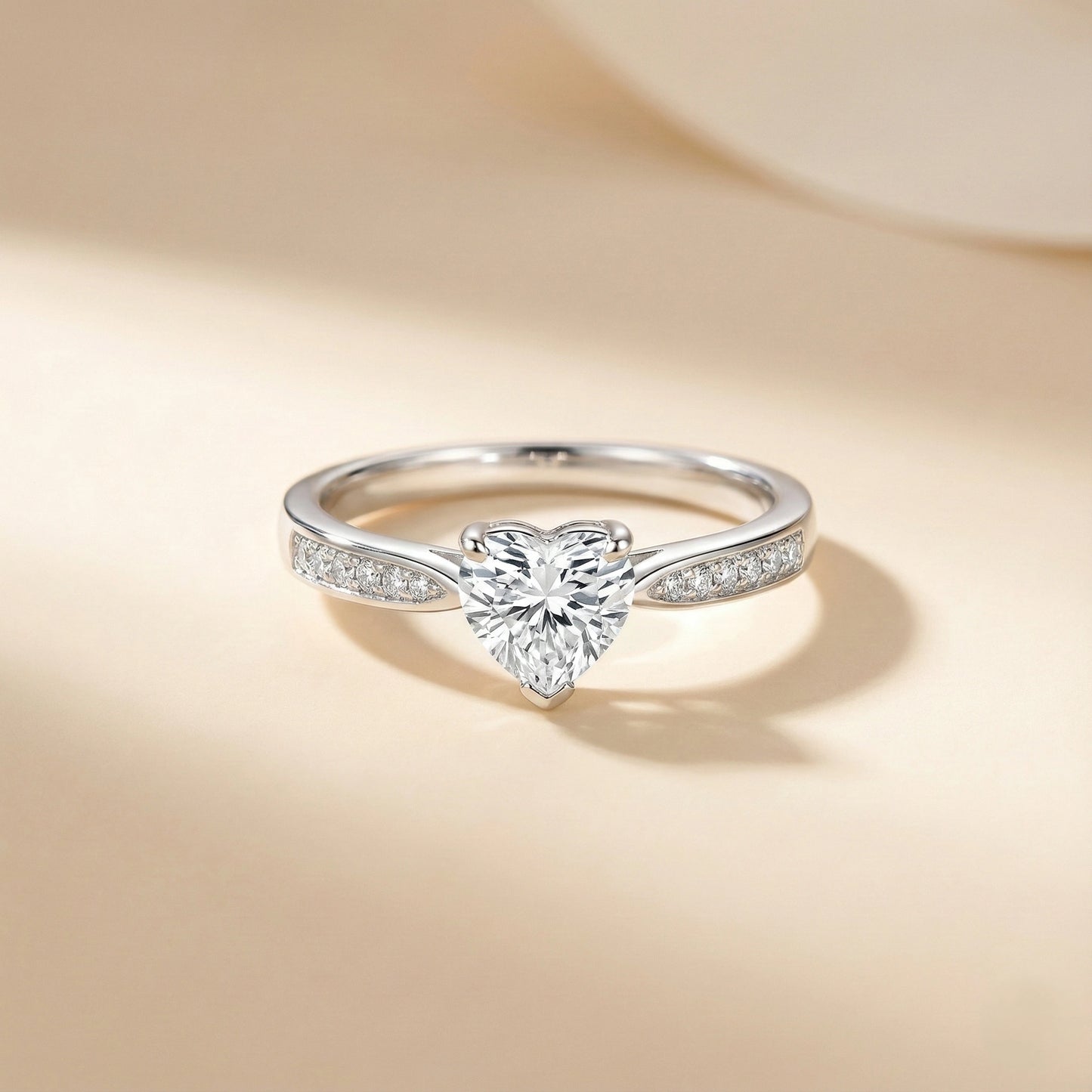 Silver ring with a heart-shaped diamond on a beige background