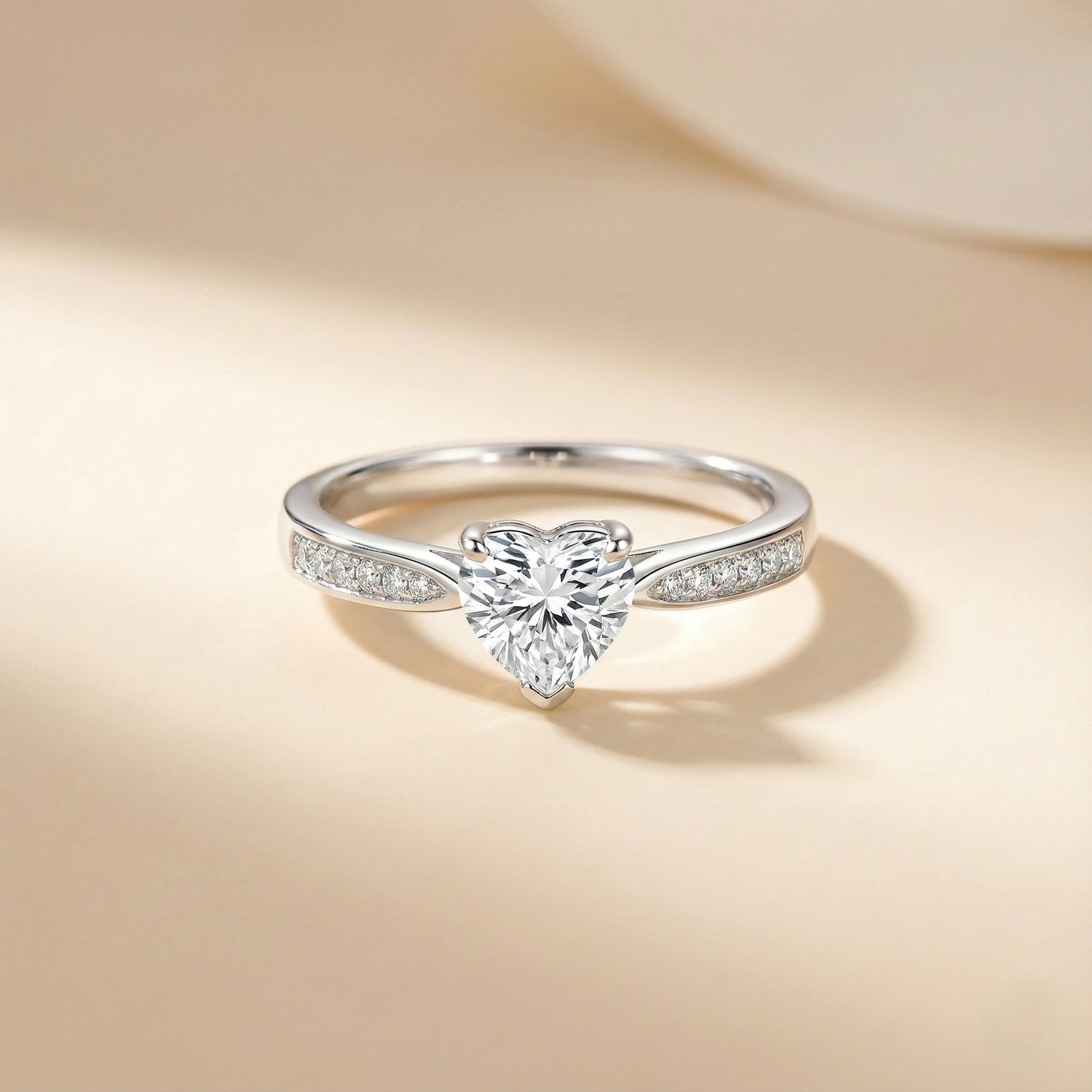 Silver ring with a heart-shaped diamond on a beige background