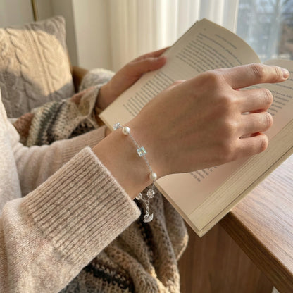 Person wearing a bracelet with a book in the background