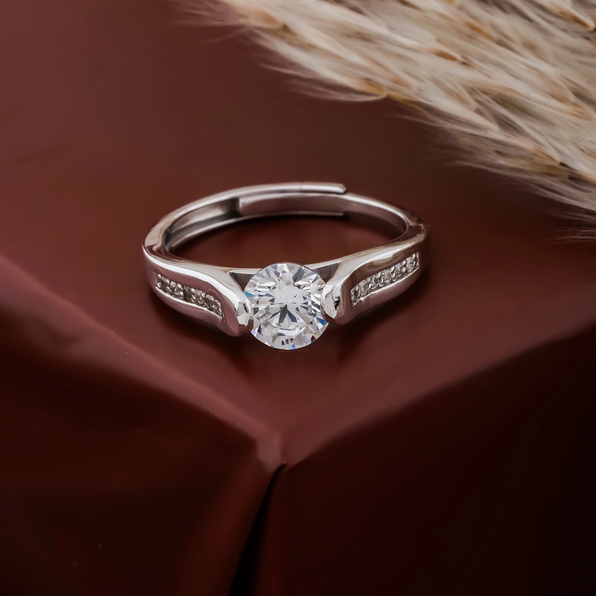 Silver ring with a diamond on a brown fabric background