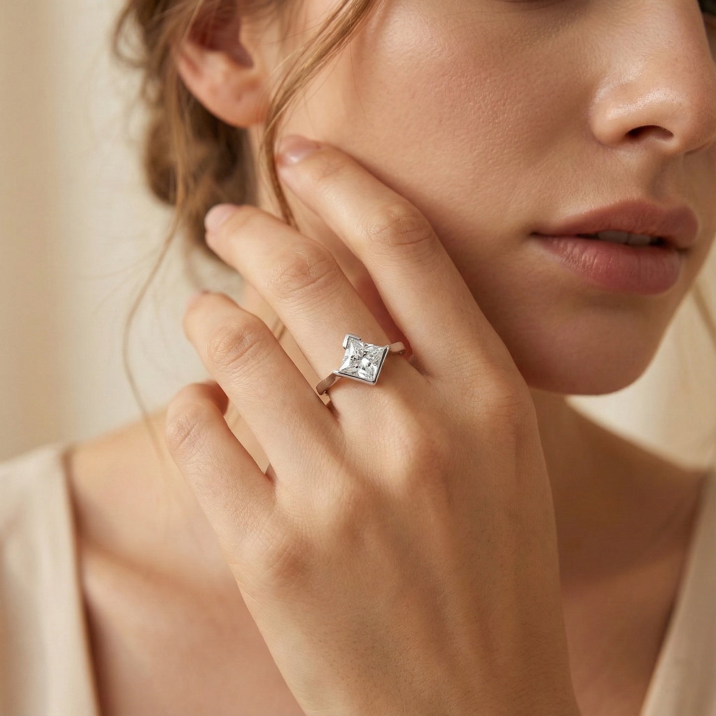 Close-up of a woman wearing a diamond ring on her finger.