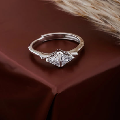 Silver ring with diamond-like stones on a brown fabric background