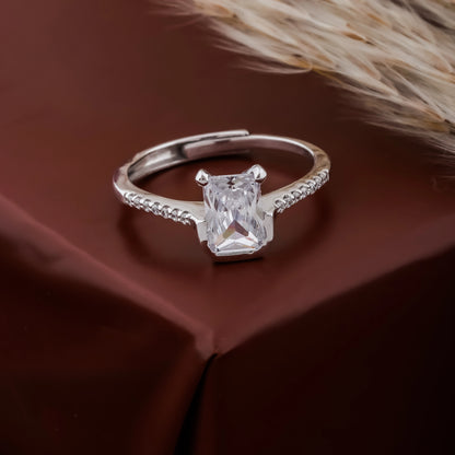 Silver ring with a large diamond on a brown fabric background