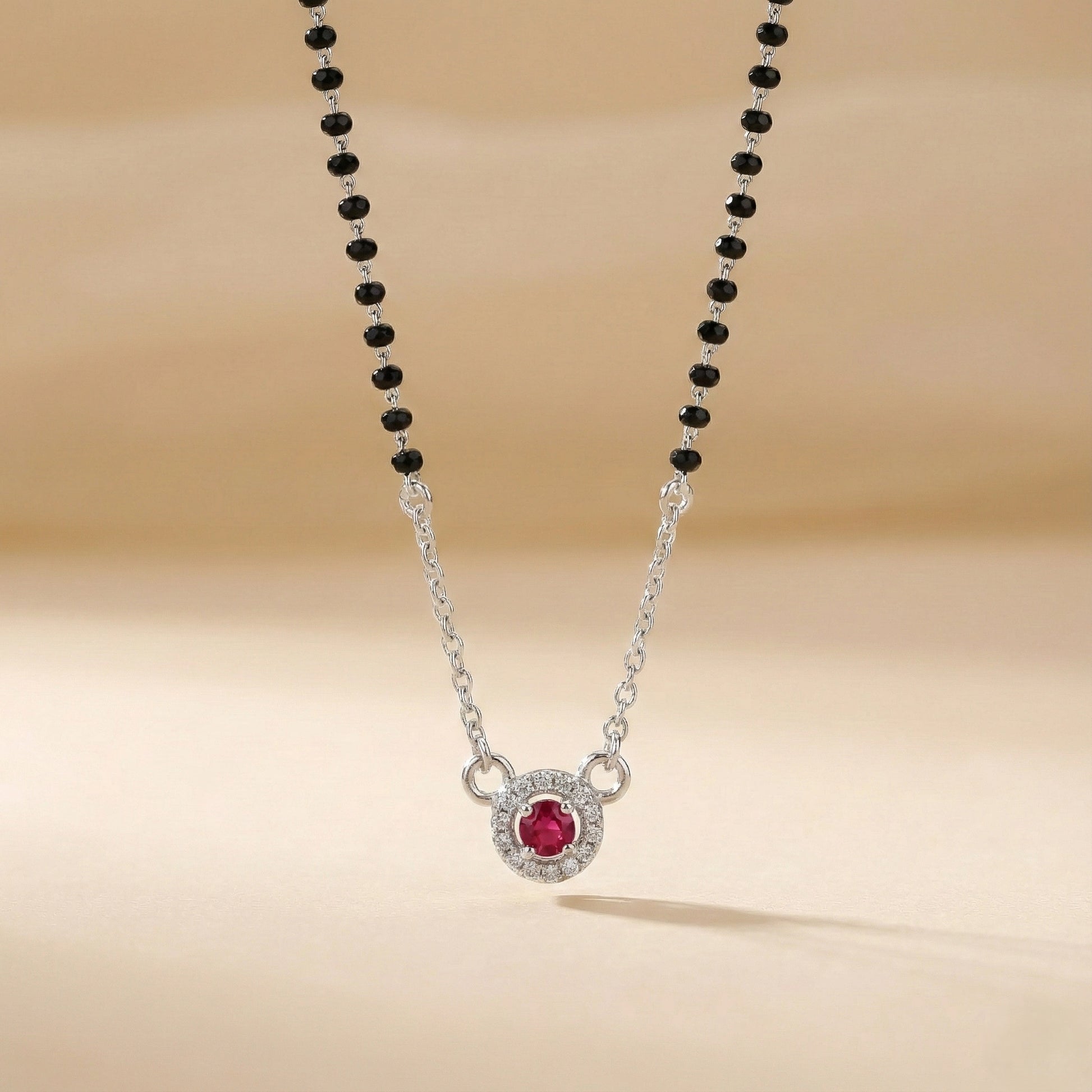 Necklace with a red gemstone pendant on a beige background