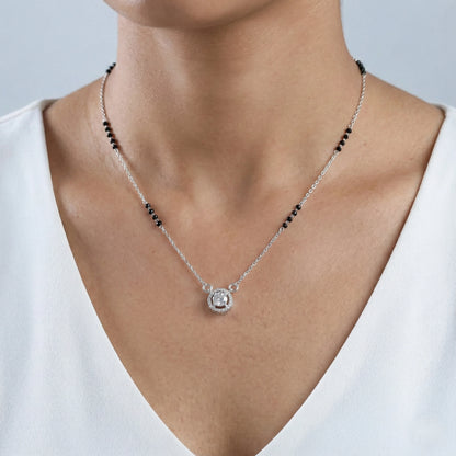 Necklace with a pendant worn by a person against a neutral background