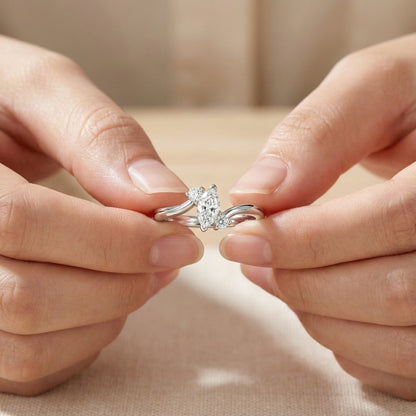 Close-up of hands holding a silver ring with a diamond