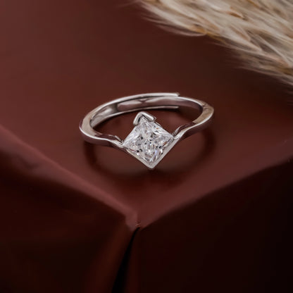Silver ring with a diamond on a brown fabric background