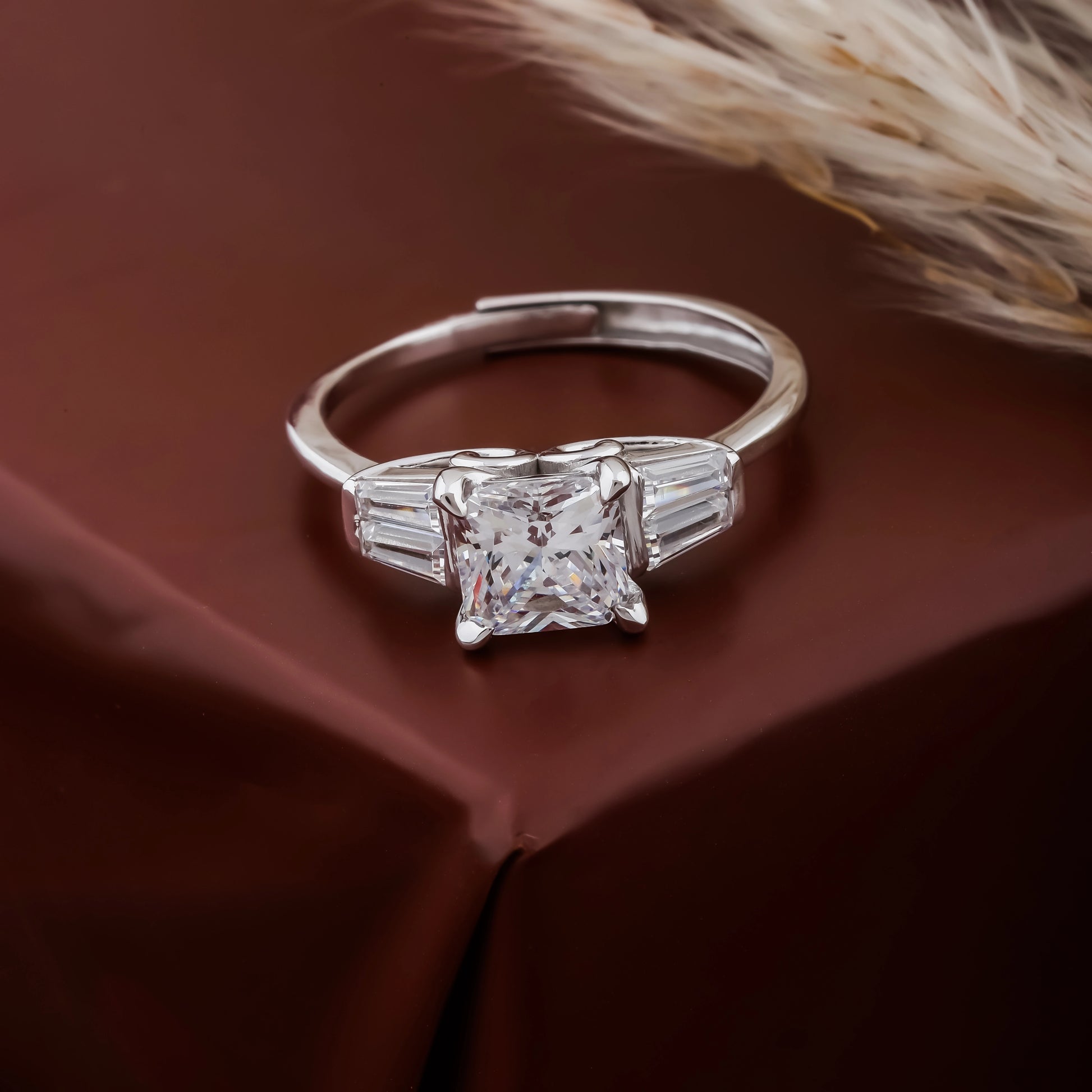 Silver ring with a diamond on a brown fabric background