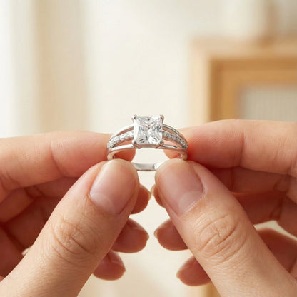Diamond ring held between two fingers against a blurred background