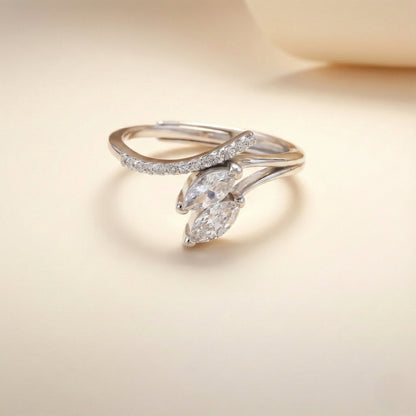 Delicate silver ring with marquise-shaped diamond on a soft beige background