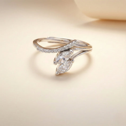 Delicate silver ring with marquise-shaped diamond on a soft beige background