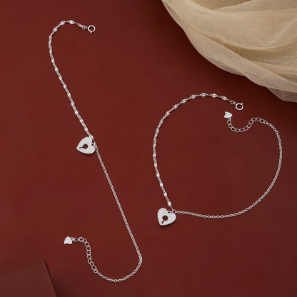 Silver anklets with heart-shaped charms on a red background