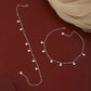 Silver necklace and bracelet set on a red background