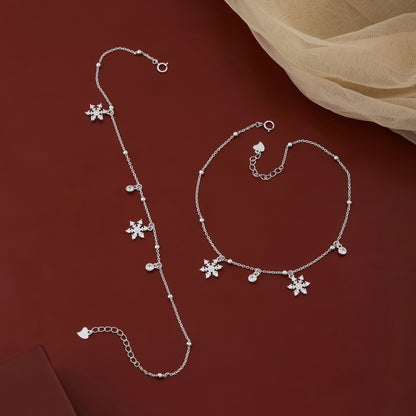 Silver bracelet with floral charms on a red background