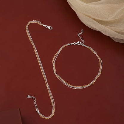 Gold necklace and bracelet set on a red background