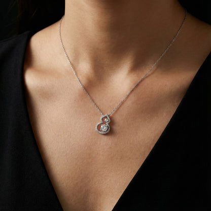 Necklace with a heart-shaped pendant worn by a person against a black background