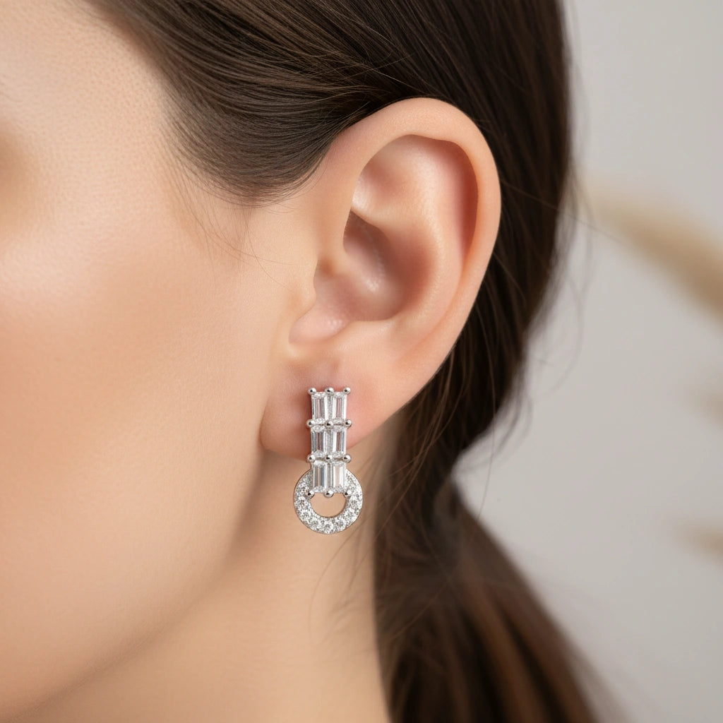 Close-up of an ear wearing a silver earring with a blurred background