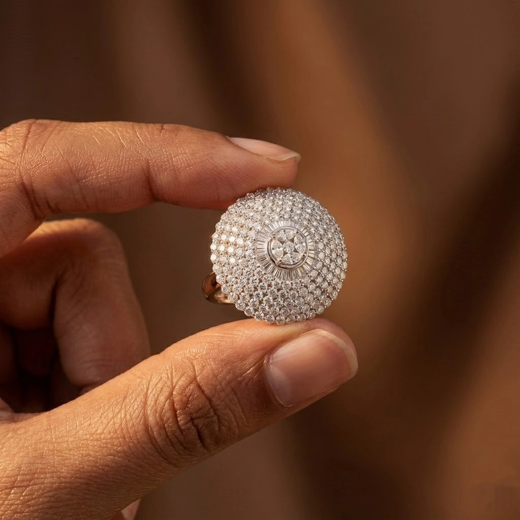 Hand holding a silver ring with intricate design against a blurred background