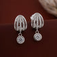 Silver earrings with diamond-like stones on a dark brown background