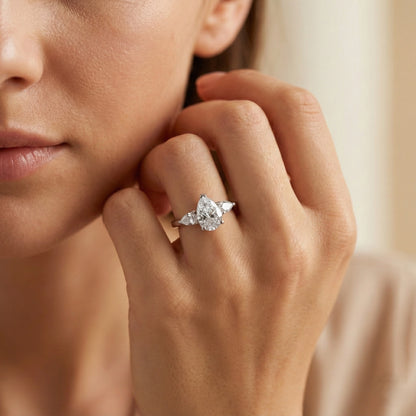 Close-up of a hand wearing a diamond ring with a blurred background