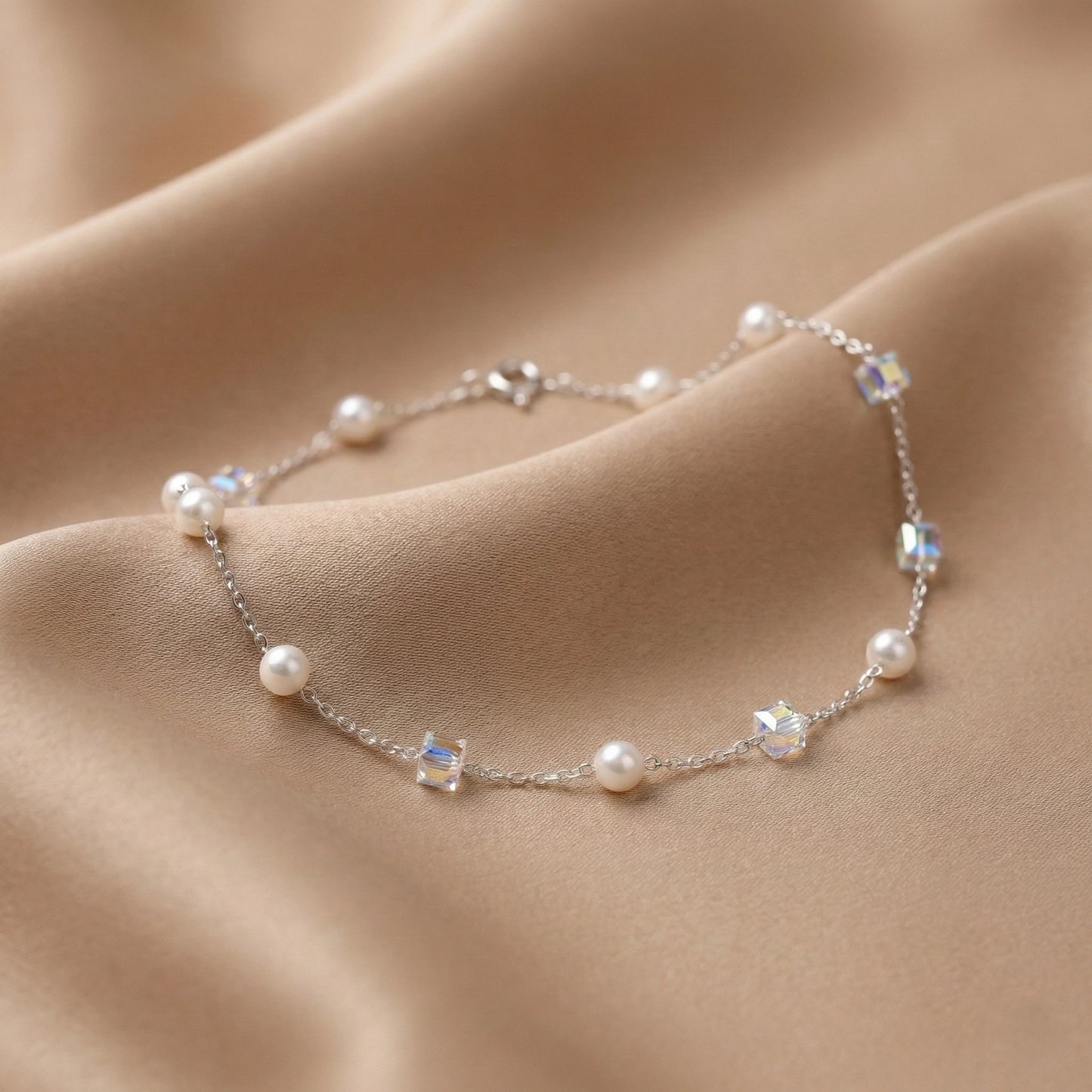 Pearl and crystal bracelet on soft beige fabric background