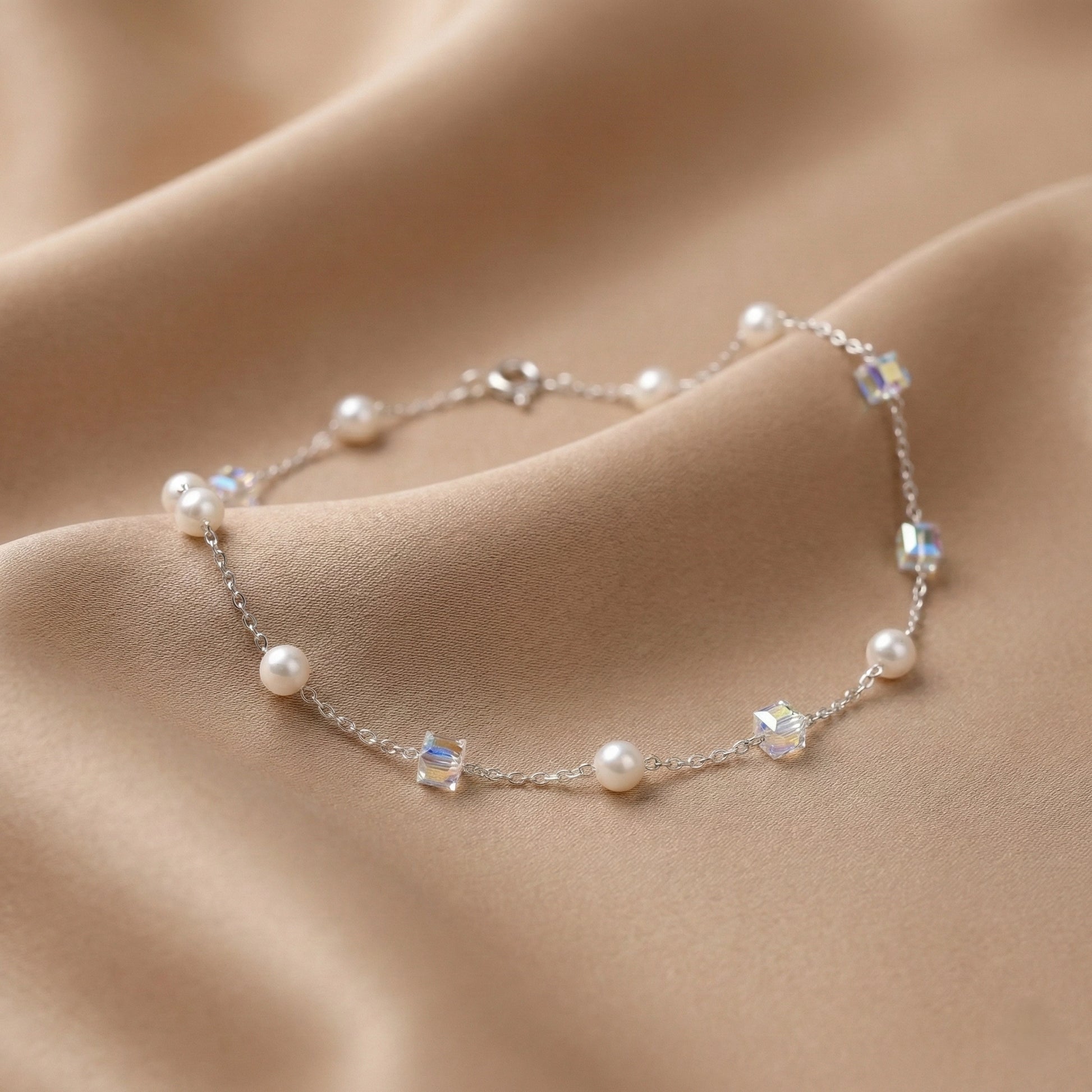 Pearl and crystal bracelet on soft beige fabric background