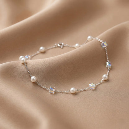 Pearl and crystal bracelet on soft beige fabric background