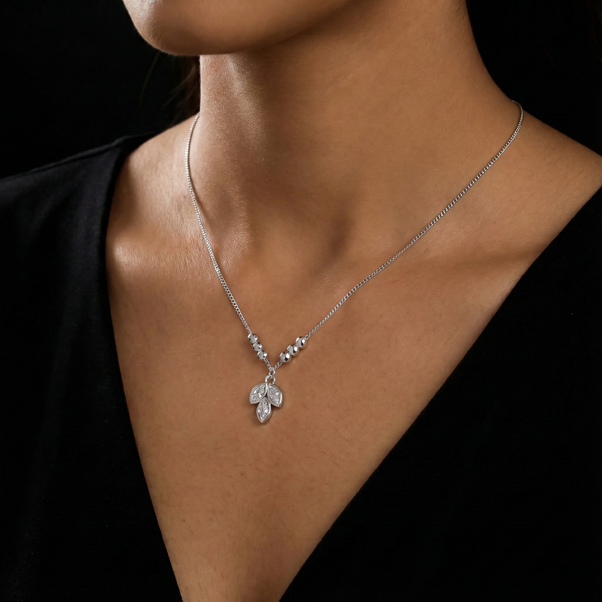 Silver necklace with a pendant on a black background