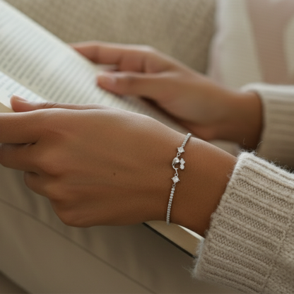 Close-up of a person's wrist wearing a silver bracelet with a neutral background