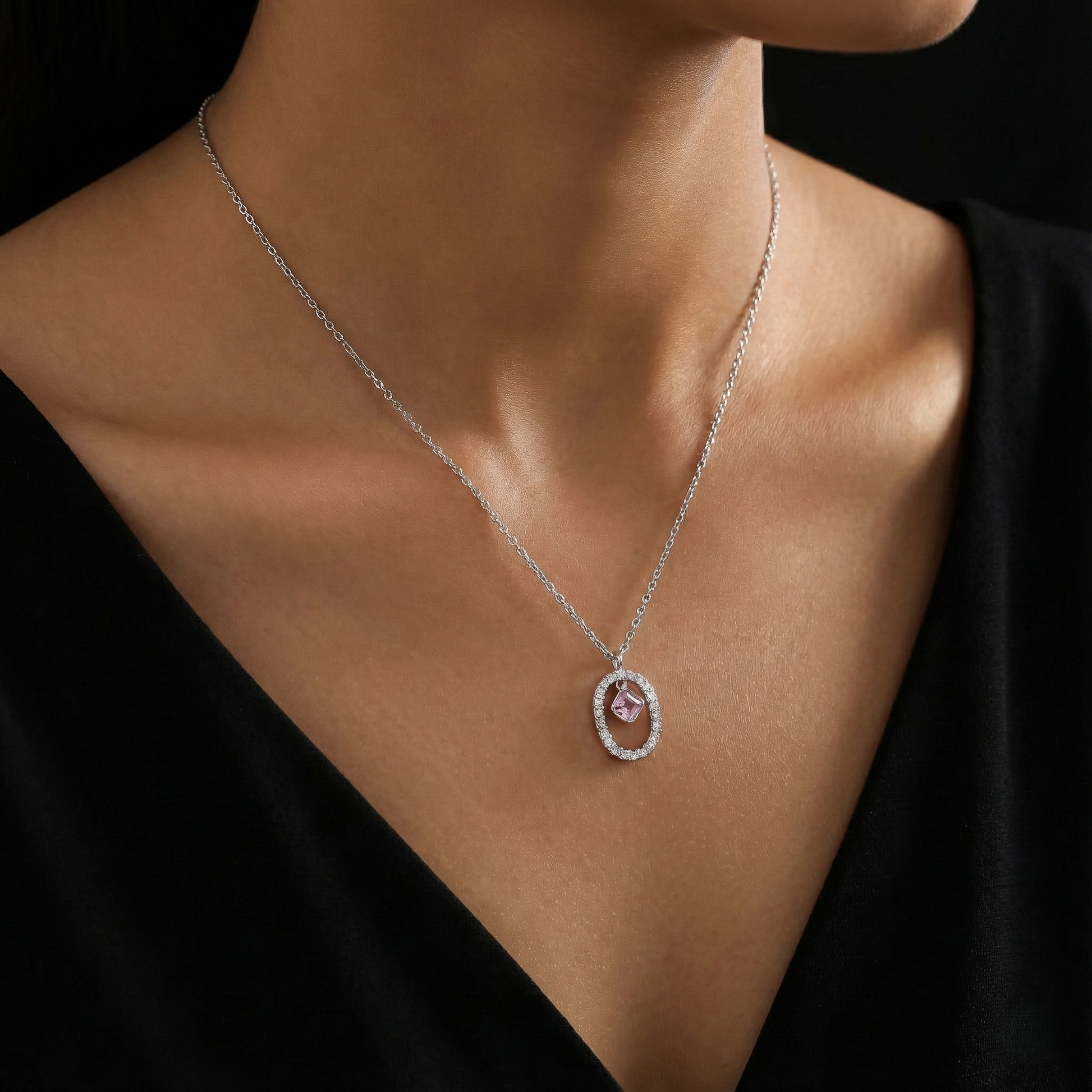 Necklace with a pink gemstone pendant on a black background
