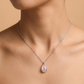 Necklace with a pink teardrop pendant on a beige background
