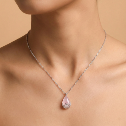 Necklace with a pink teardrop pendant on a beige background
