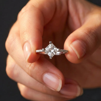 Close-up of a hand wearing a diamond ring with a blurred background