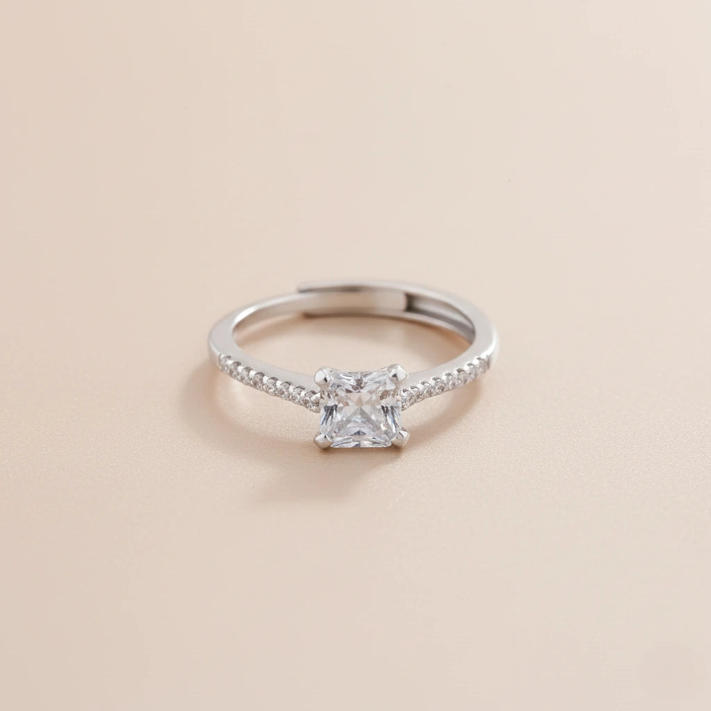 Silver ring with a diamond on a beige background