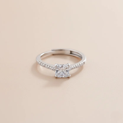 Silver ring with a diamond on a beige background