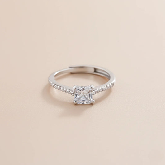 Silver ring with a diamond on a beige background