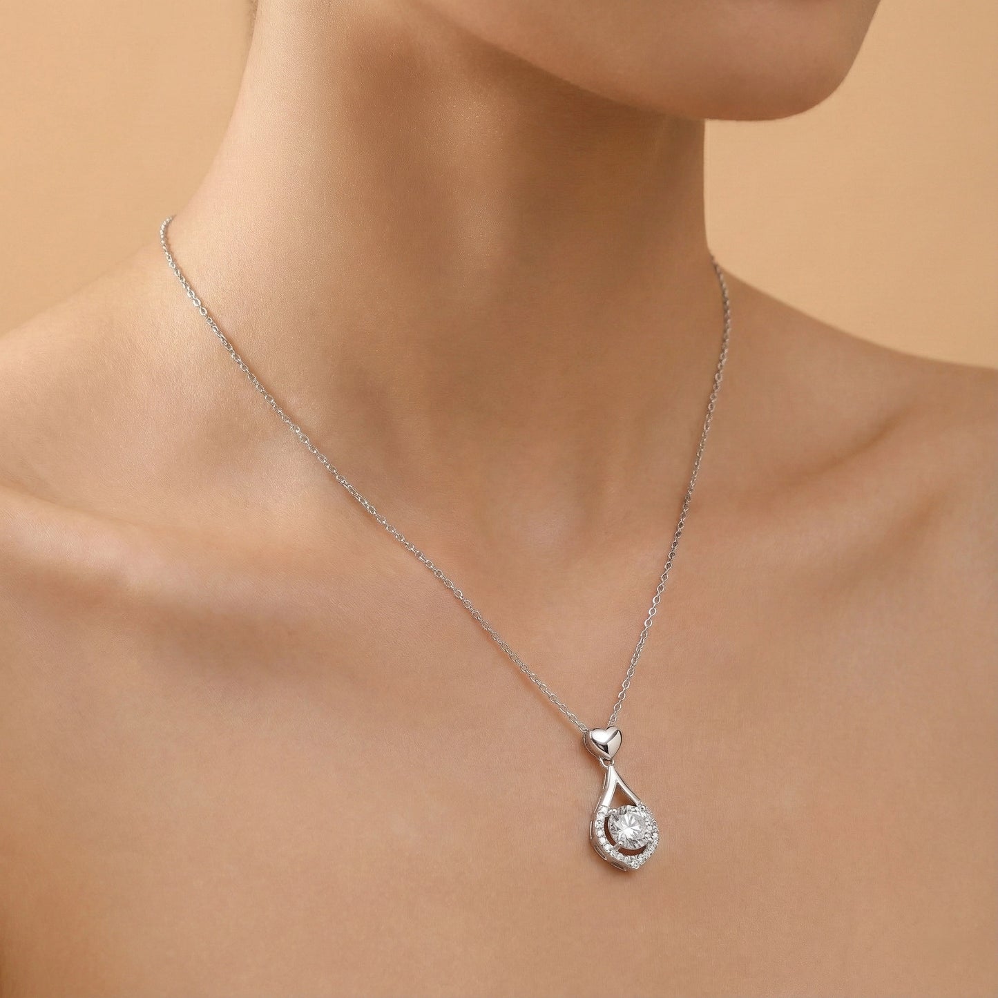 Silver necklace with a teardrop-shaped pendant on a neutral background