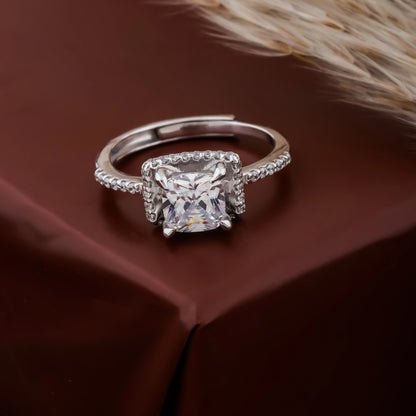 Silver ring with a large diamond on a brown fabric background