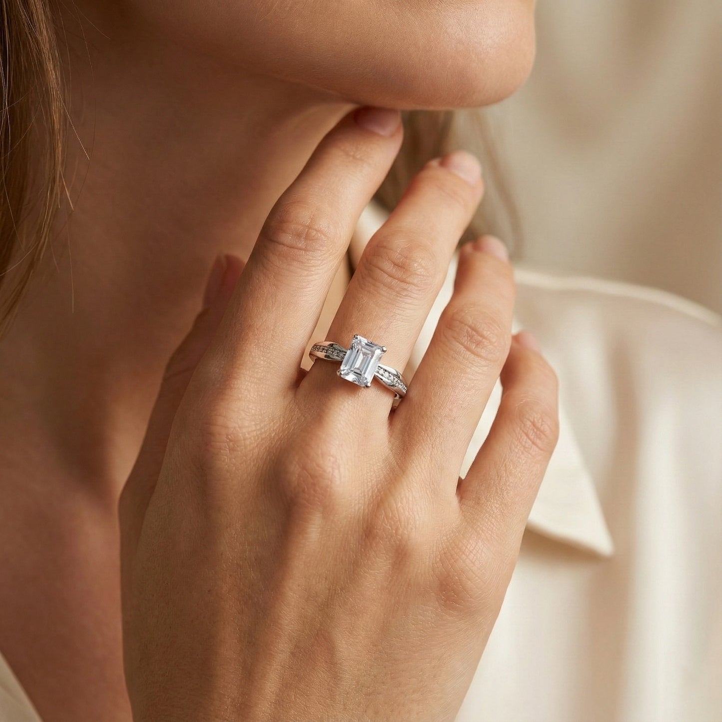 Close-up of a hand wearing a diamond ring with a soft background