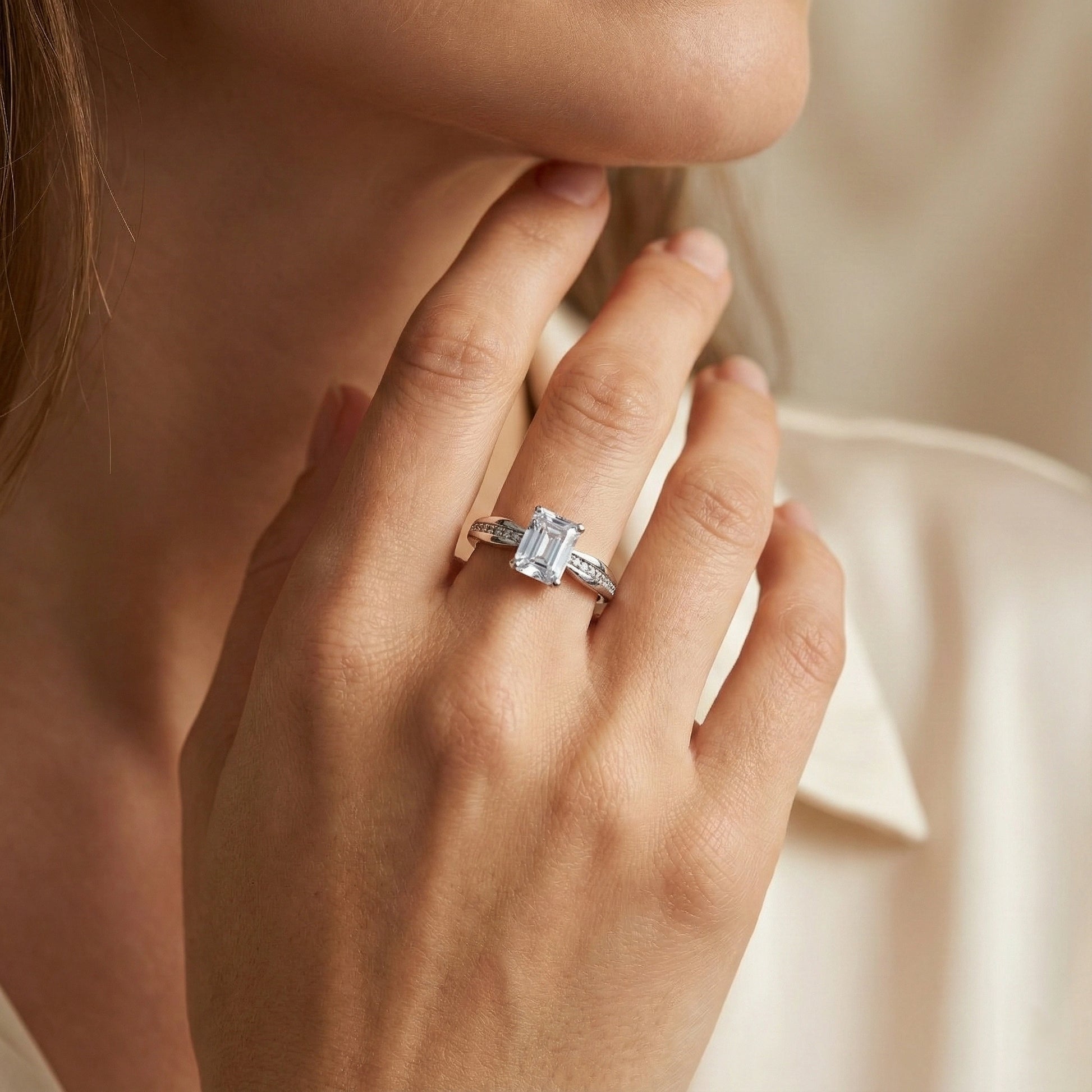 Close-up of a hand wearing a diamond ring with a soft background