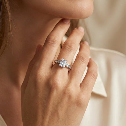 Close-up of a hand wearing a diamond ring with a soft background