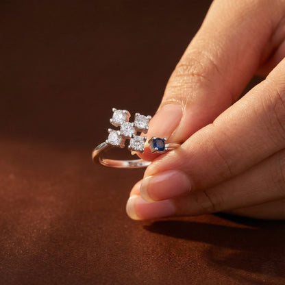 Close-up of a hand holding a diamond ring with a brown background