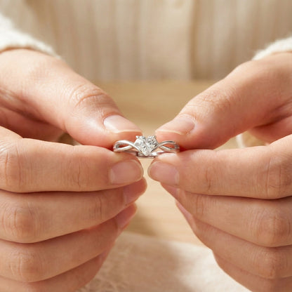 Close-up of hands holding a diamond ring with a blurred background