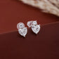 Heart-shaped diamond earrings on a brown surface
