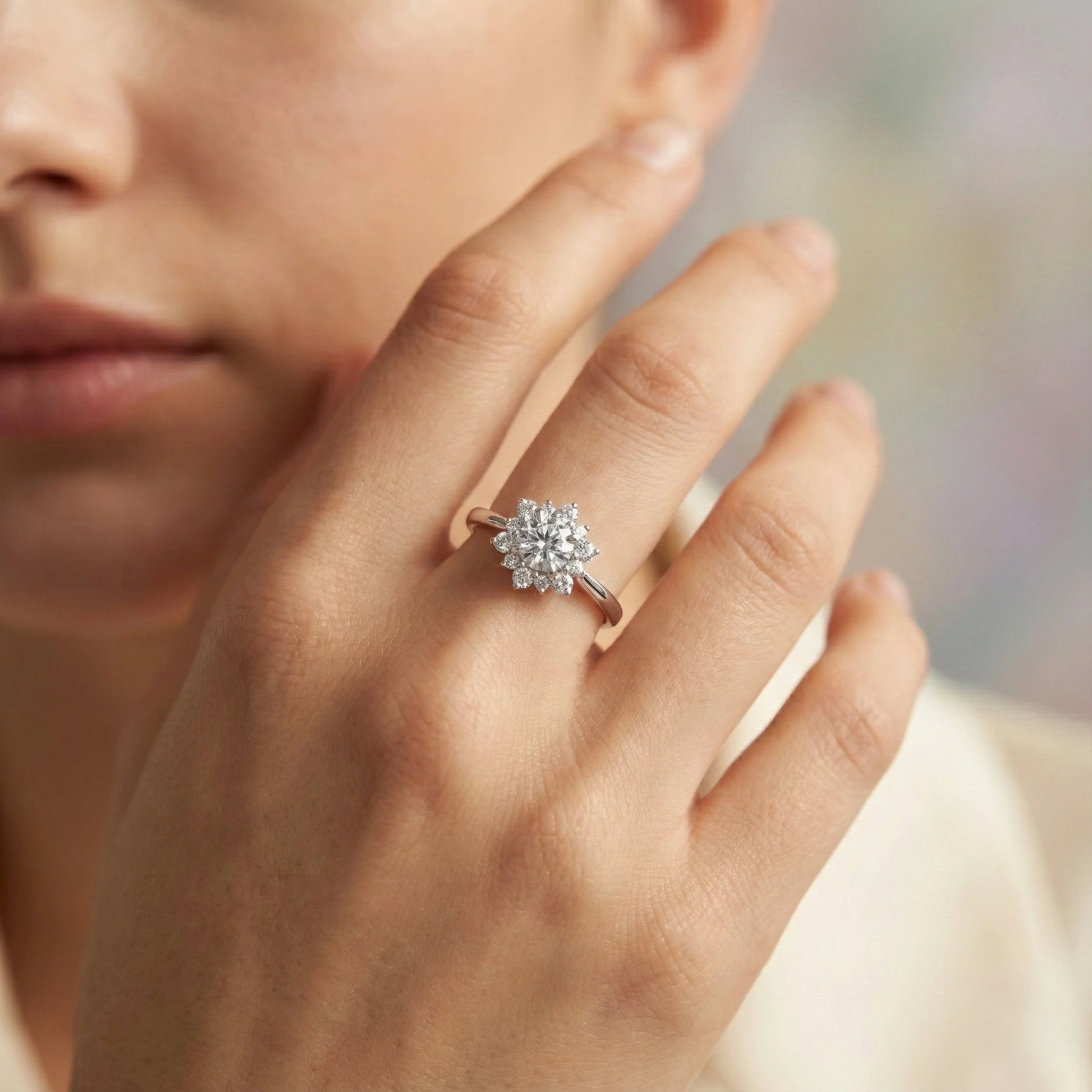Close-up of a hand wearing a diamond ring with a blurred background